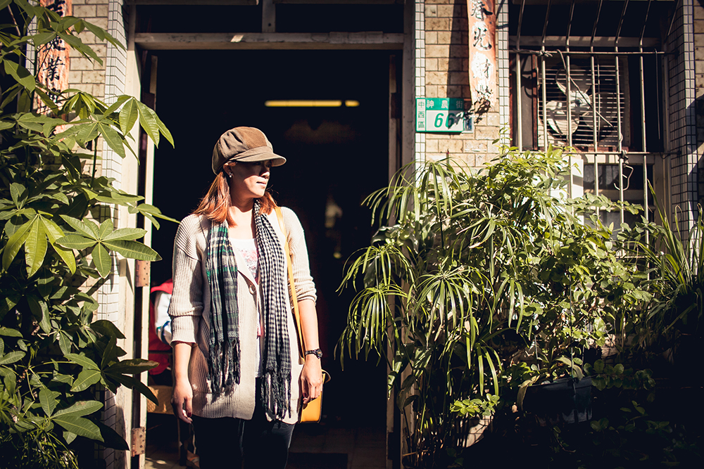 Girl with fancy hat standing in doorway of old house in Shennong Street