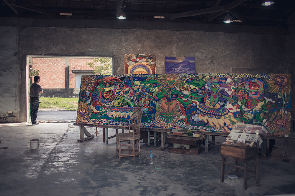 Large paining in a former warehouse room with artist standing by the door looking outside