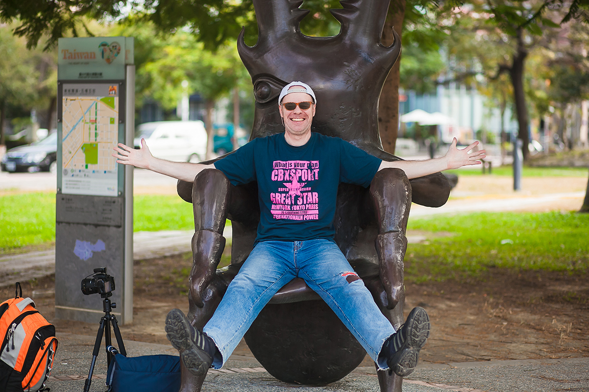 Guy sitting on giant bug chair on Art Museum Parkway in Taichung City