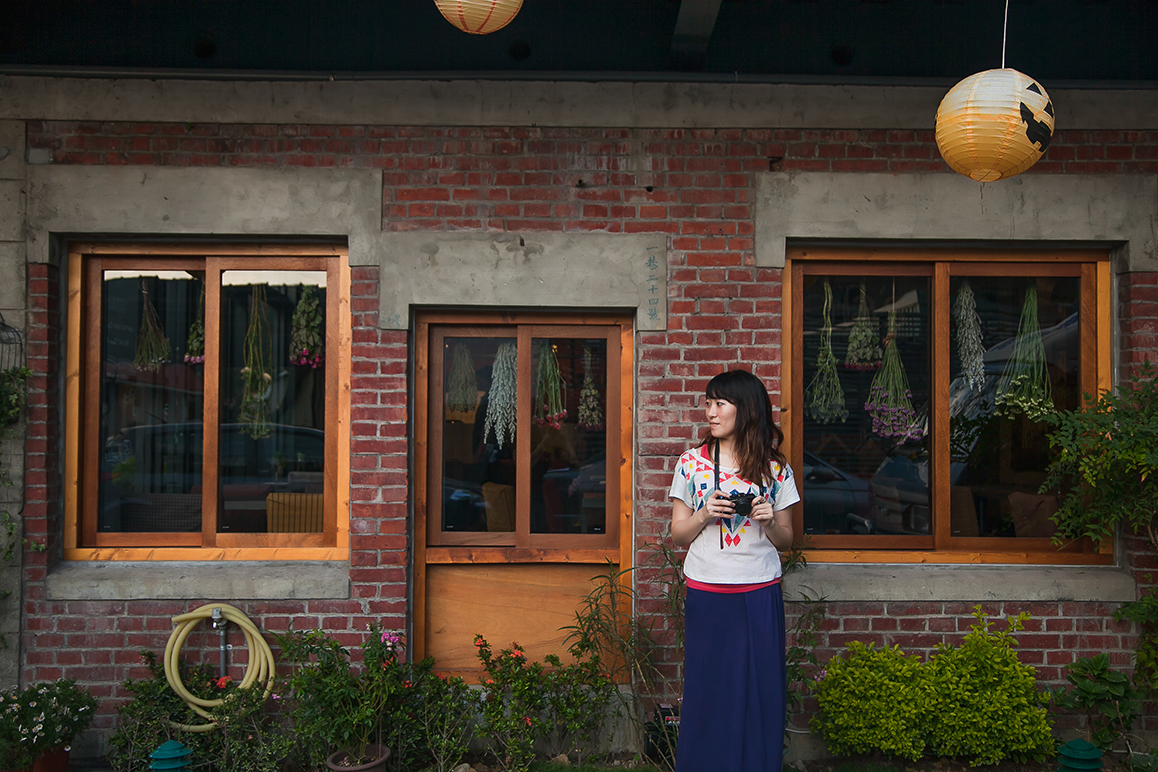 Girl with camera standing outside old house in Fantasy Story neighborhood