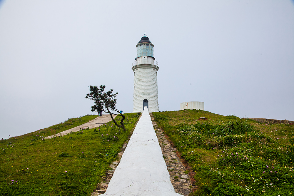 Look over the white wall leading to Dongquan Lighthouse