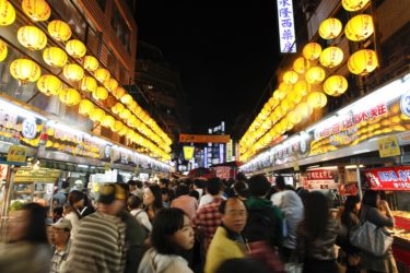 People in Keelung's night market with yellow lanterns above