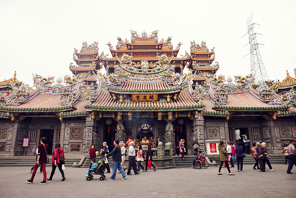 Guandu Temple with people walking in front of it