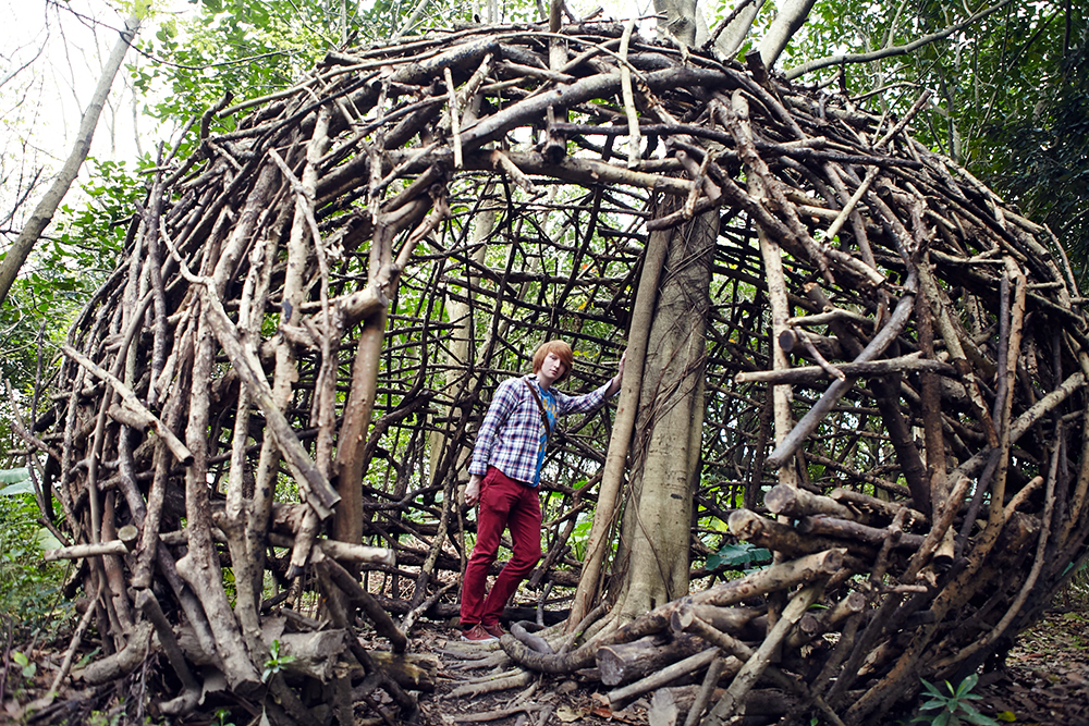 Writer standing inside art installation made of wood
