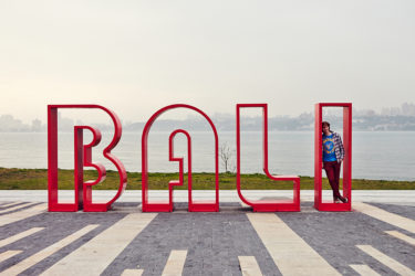 Writer standing inside a large "BALI" sculpture