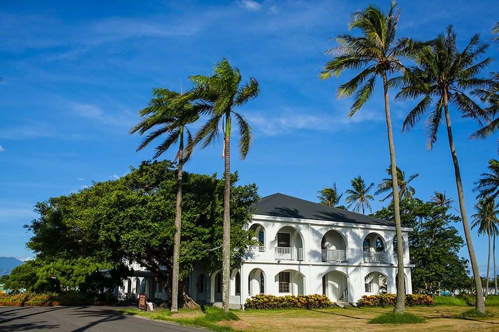 Dapeng Bay Cultural Museum, a colonial building with white walls and palm trees