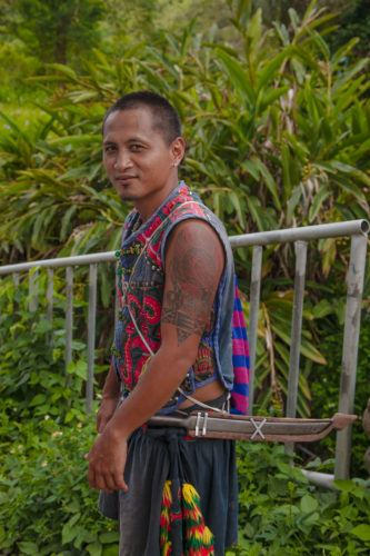 Young member of the Paiwan tribe posing for photo
