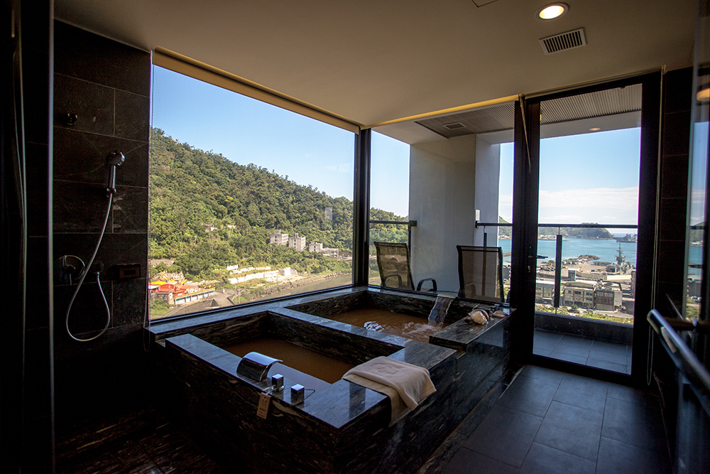 Guestroom hot-spring bath with mountain and harbor view