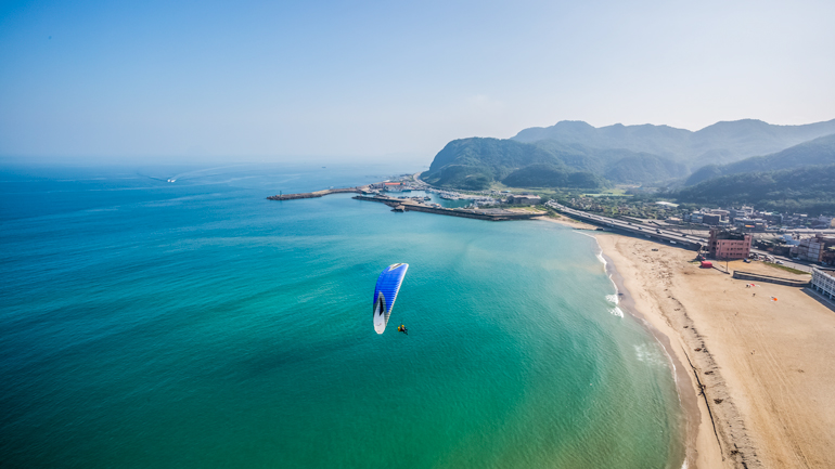 Paragliding over the azure waters of Green Bay